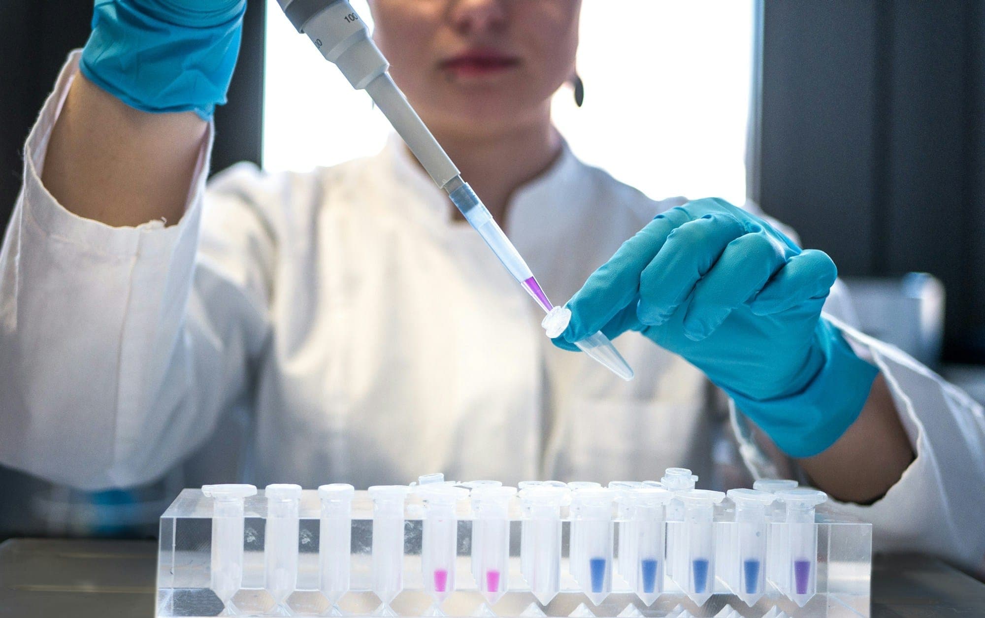 A technician pipetting a sample in a testing laboratory